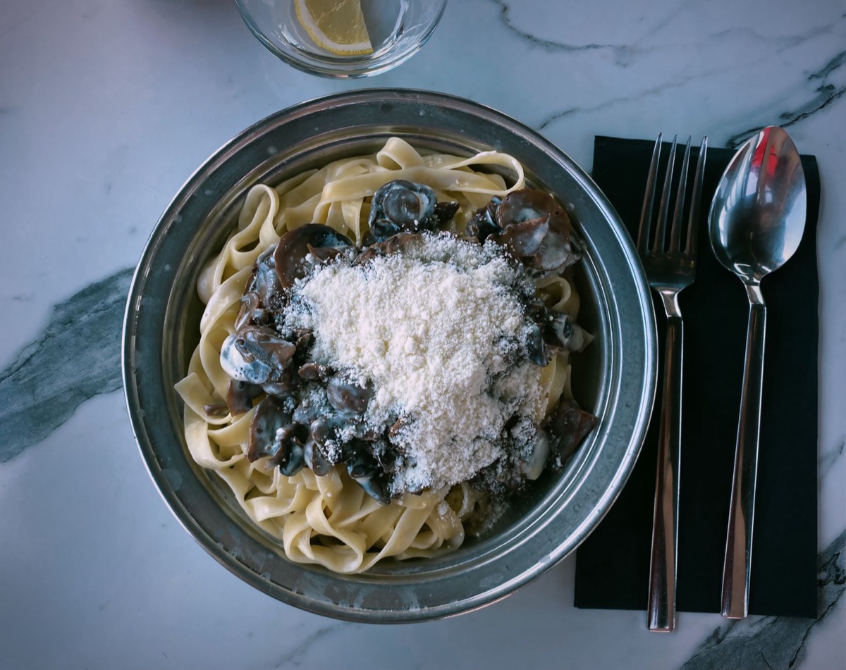 Romige fettuccine met champignons in een witte kom